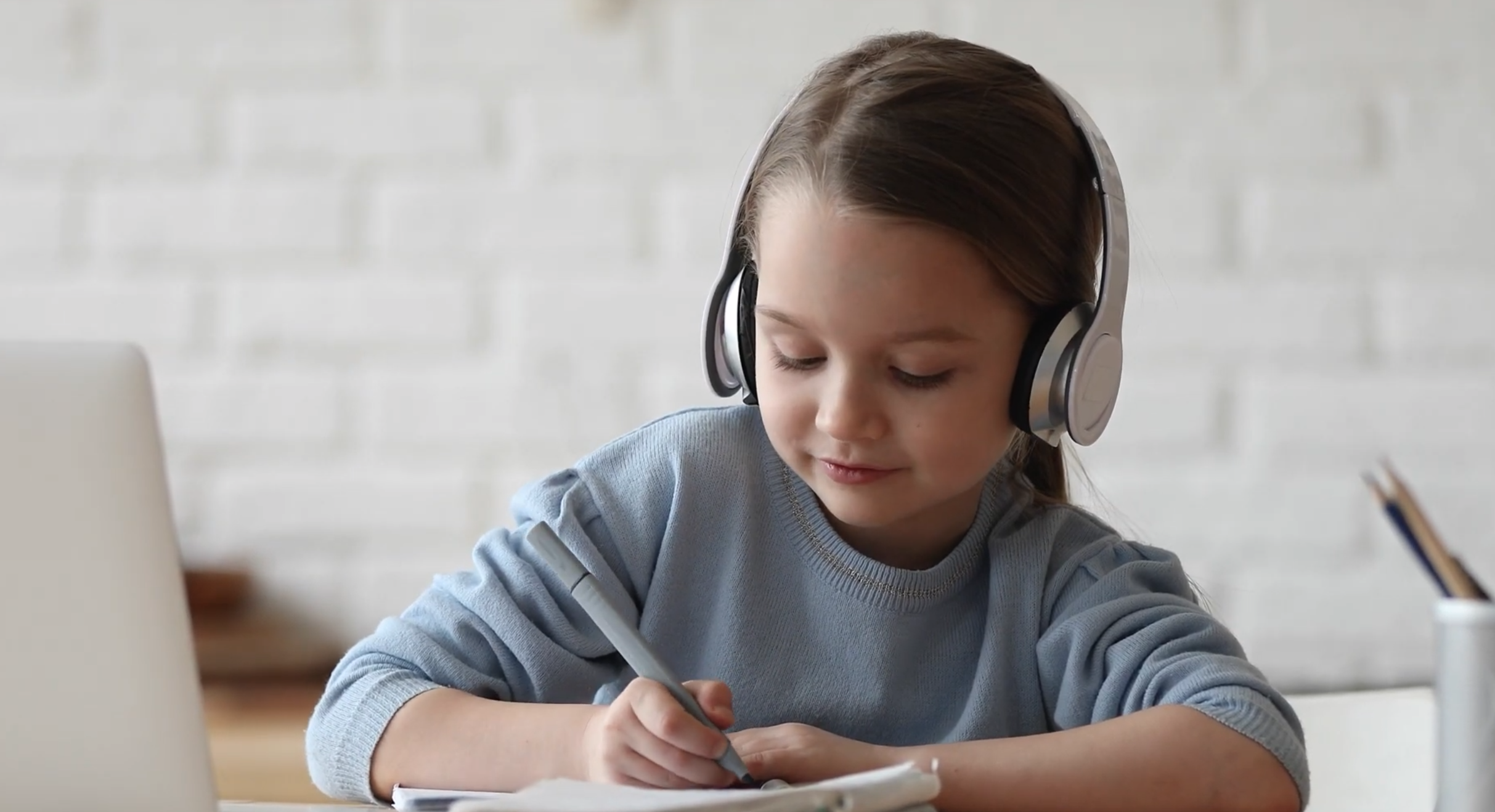 kid doing homework with headphones on